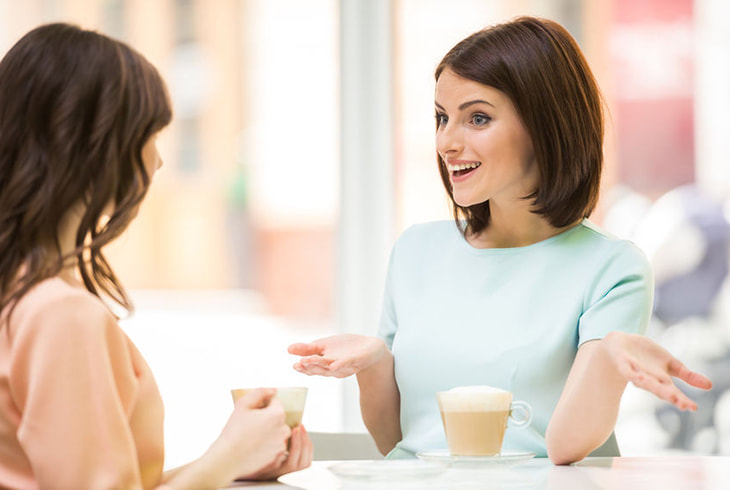 Two ladies talking while drinking coffee