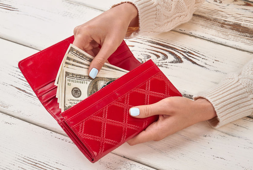 Woman holding wallet with money